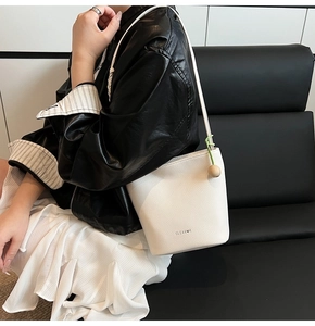 Detailed shot of white litchi pattern bucket bag with decorative wooden ball charm