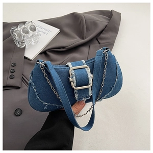 Detail of blue denim underarm bag featuring distressed edges and a silver metal buckle