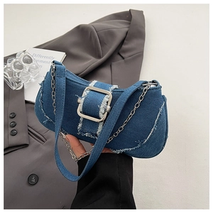 Detail of blue denim shoulder bag featuring a silver square buckle and metal chain strap
