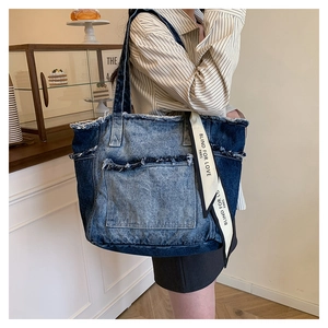 Détail des bords effilochés d'un sac en denim avec ruban décoratif Blind For Love