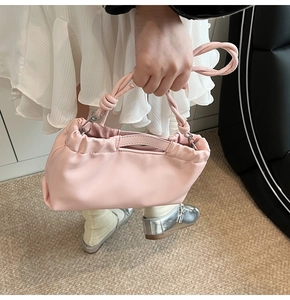 Detailed close-up of light pink drawstring PU leather handbag with braided handle details