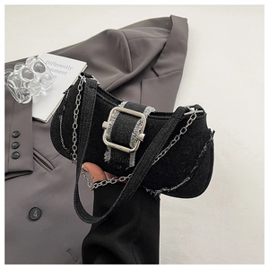 Detailed close-up of distressed denim shoulder bag with silver buckle and chain strap