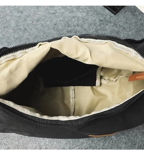 Detail shot of the black nylon bag interior featuring a beige lining and inner pocket