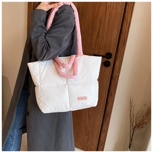 Détail du sac fourre-tout matelassé blanc avec anses roses et étiquette FASHION