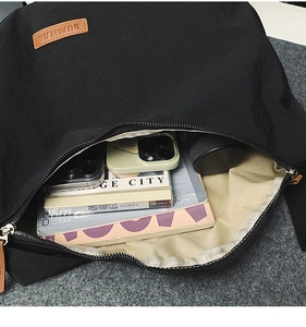 Interior view of large black nylon crossbody bag showing spacious storage and lining