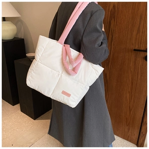 Gros plan sur le sac fourre-tout matelassé blanc avec anses roses et étiquette FASHION