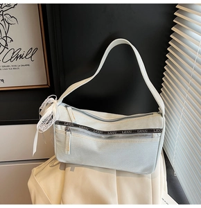 Detailed macro shot of light blue denim bag featuring zipper accents and white lace bow