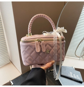 Detailed shot of pink quilted mini handbag with gold flower clasp and lace bow detail
