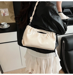 Detailed close-up of cream PU shoulder bag featuring drawstring design and braided strap