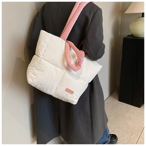 Détail du sac fourre-tout matelassé blanc avec anses roses et étiquette mode