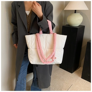 Sac fourre-tout matelassé crème avec doubles anses roses dans un décor moderne et chic