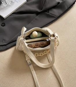 Interior view of cream leather chain bag showing capacity for phone and cosmetics