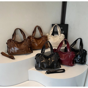 Detail of vintage tote bags with metallic rivets and adjustable straps in five colors