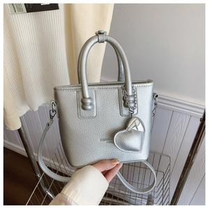 Detailansicht der silbernen Mini-Tasche mit Lychee-Struktur und Herzanhänger