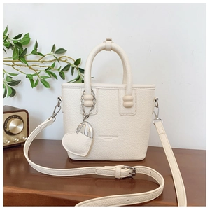 Detail der Lederhandtasche mit Herzanhänger und verstellbarem Schultergurt