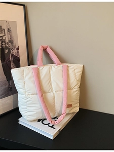 Sac fourre-tout matelassé beige avec anses roses sur un présentoir minimaliste