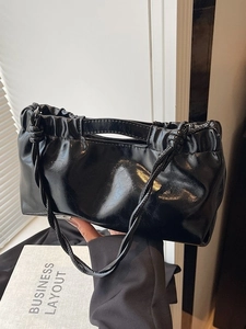 Minimalist black glossy PU leather handbag with pleated detail and woven shoulder strap