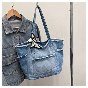 Détail du grand sac cabas en jean délavé avec bords effilochés et foulard en soie