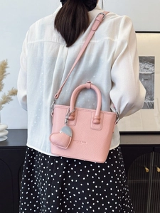 Rosafarbene Eimertasche mit Lederherzanhänger und verstellbarem Schultergurt