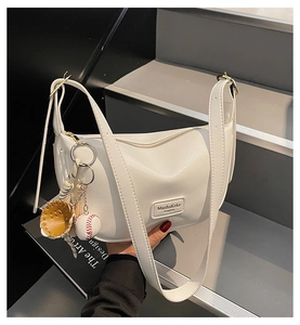 Gros plan du sac bandoulière blanc à texture grainée avec pendentif de baseball
