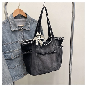Vue détaillée du sac cabas en jean gris foncé avec bords effilochés et foulard en soie
