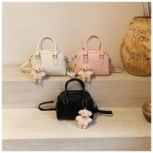 Chic Boston bags in white, pink, and black with cute teddy bear charms on stone stairs