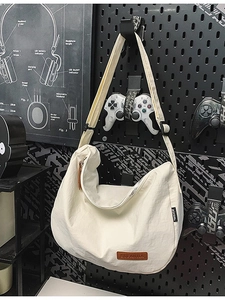 Chic beige nylon crescent bag with adjustable wide strap and front leather logo patch