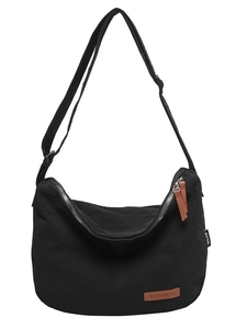 Black nylon crescent crossbody bag with adjustable strap and dual leather zippers