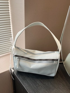 Light blue denim baguette bag with lettered ribbon and lace ribbon detail on the strap