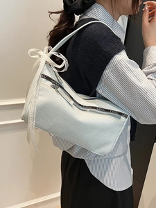 Light blue denim baguette bag with lace bow decoration and lettered strap details