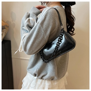 Glossy black chain strap handbag styled with a grey sweatshirt and white lace skirt
