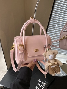 Pink minimalist box handbag with gold hardware and a cute plush bear charm