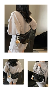 Détail du sac demi-lune noir en similicuir brillant avec bandoulière réglable