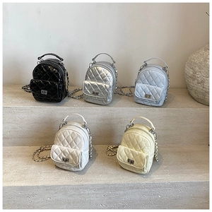Detailed row of quilted mini backpacks in black, silver, blue, white and beige colors