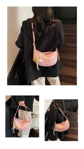 Détail du sac bandoulière demi-lune rose avec charm d'ours et sangle réglable