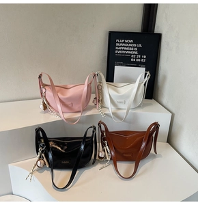 Vue détaillée de quatre couleurs de sacs à bandoulière en cuir souple avec breloque baseball