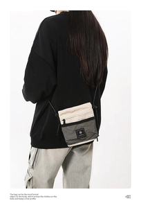 Detail showing the beige functional crossbody bag with black mesh pocket on a person