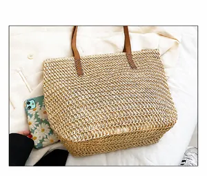 Gros plan du sac cabas tressé avec poignées en similicuir marron et texture ajourée
