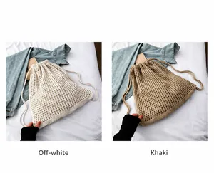 Detail von cremeweißen und khakifarbenen Strickrucksäcken mit Kordelzug und Lochmuster