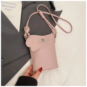 Dettaglio borsa quadrata in pelle litchi rosa con ciondolo a cane e chiusura in metallo