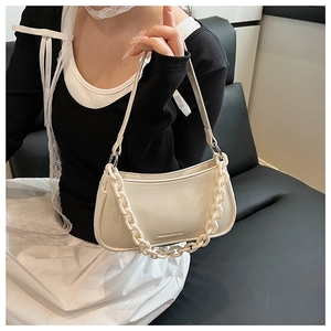 Detailed close-up of cream-white dumpling bag with textured PU leather and chunky chain strap