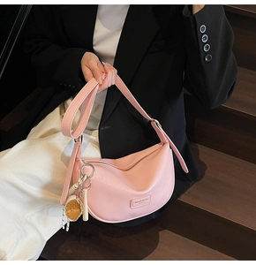 Gros plan détaillé du sac hobo rose avec un pendentif de baseball créatif sur le cuir