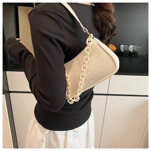 Detail view of cream white underarm bag with thick resin chain and retro faux leather texture