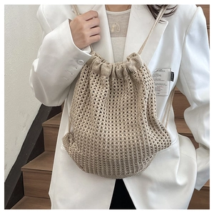 Detail of beige crochet drawstring backpack with hollow mesh knit texture on a model