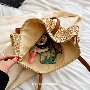 Vue intérieure montrant la grande capacité du sac cabas beige tissé avec anses en cuir