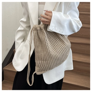 Detail of beige crochet drawstring backpack showing mesh texture and minimalist style