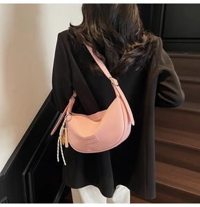 Vue détaillée du sac hobo rose avec texture grainée et boucles métalliques argentées