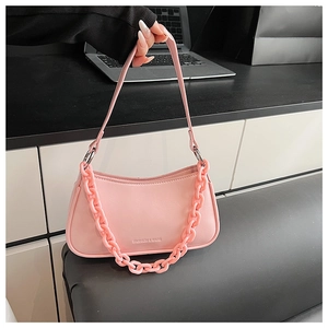 Detailed view of pink dumpling bag with thick acrylic chain and embossed logo