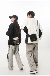Crossbody utility bag showing beige and black nylon texture with mesh pocket detail