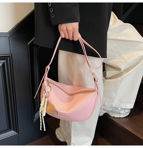 Sac bandoulière rose en forme de croissant avec charm ours et détail de bandoulière